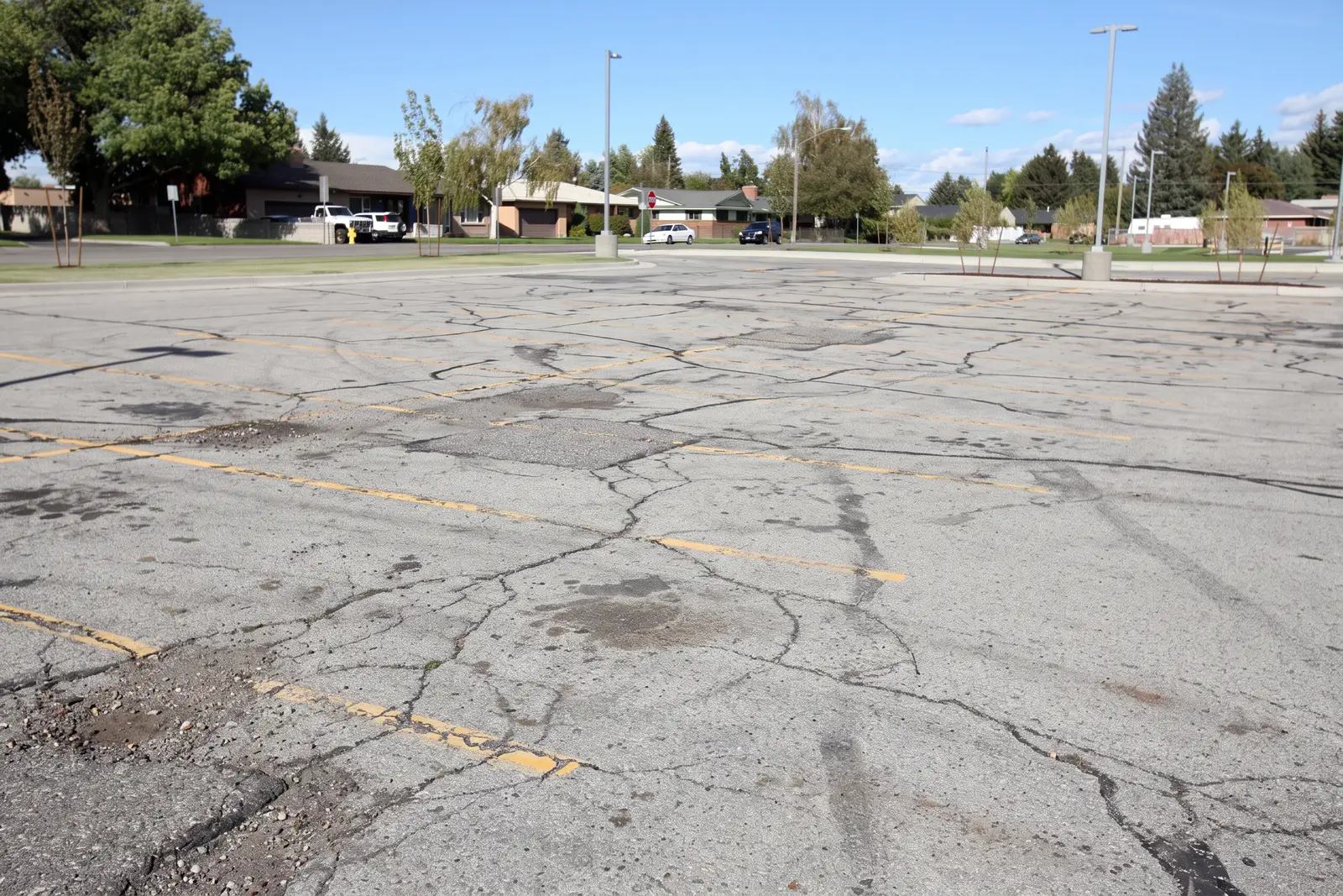Faded, cracked parking lot with worn yellow striping