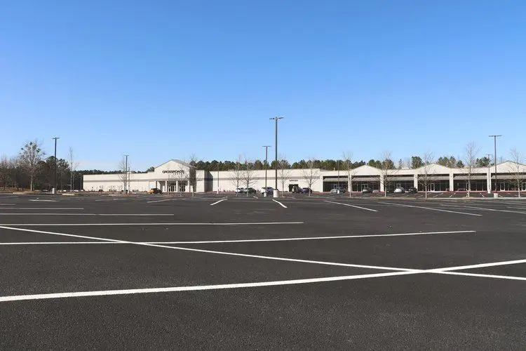 Freshly paved commercial parking lot with new white striping