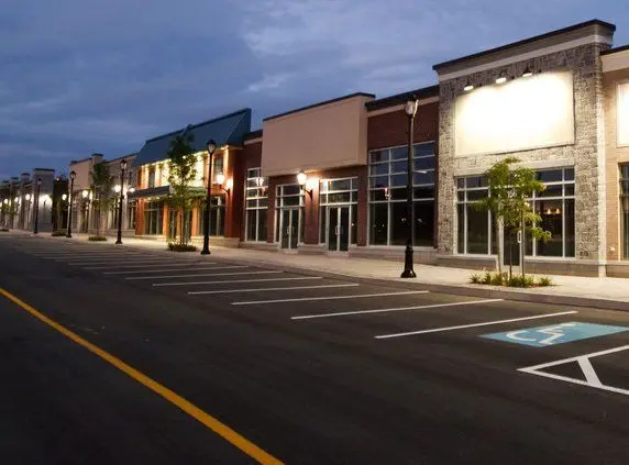 Seal-coated and striped shopping center parking lot at dusk
